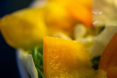 Salatalık, marul ve diğer sebzeleri dilimleyen bir kadının ev yapımı salatanın tazeliğini ve sağlığını yakaladığı canlı bir mutfak sahnesi..