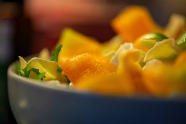 Salatalık, marul ve diğer sebzeleri dilimleyen bir kadının ev yapımı salatanın tazeliğini ve sağlığını yakaladığı canlı bir mutfak sahnesi..