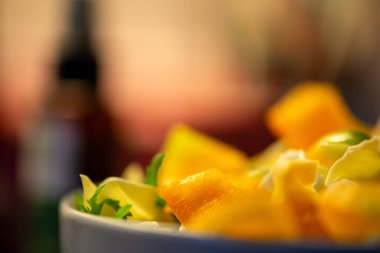 Salatalık, marul ve diğer sebzeleri dilimleyen bir kadının ev yapımı salatanın tazeliğini ve sağlığını yakaladığı canlı bir mutfak sahnesi..