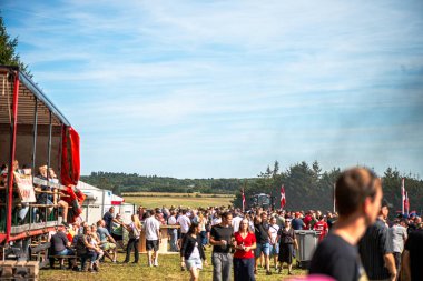 Aarhus, Danimarka. 16 Ağustos 2025 Güçlü makinelerin neşeli festival kalabalığından önce ağır topları çamura sürüklediği bir yarışma..