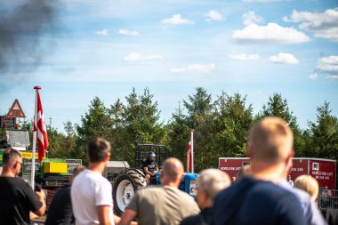 Aarhus, Danimarka. 16 Ağustos 2025 Güçlü makinelerin neşeli festival kalabalığından önce ağır topları çamura sürüklediği bir yarışma..