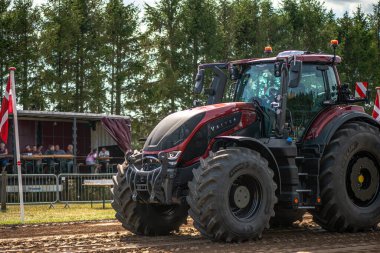 Aarhus, Danimarka. 16 Ağustos 2025 Güçlü makinelerin neşeli festival kalabalığından önce ağır topları çamura sürüklediği bir yarışma..