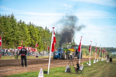 Aarhus, Danimarka. 16 Ağustos 2025 Güçlü makinelerin neşeli festival kalabalığından önce ağır topları çamura sürüklediği bir yarışma..