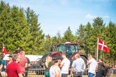 Aarhus, Danimarka. 16 Ağustos 2025 Güçlü makinelerin neşeli festival kalabalığından önce ağır topları çamura sürüklediği bir yarışma..