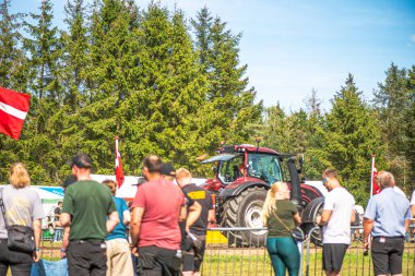 Aarhus, Danimarka. 16 Ağustos 2025 Güçlü makinelerin neşeli festival kalabalığından önce ağır topları çamura sürüklediği bir yarışma..