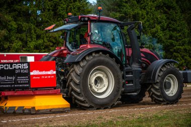 Aarhus, Danimarka. 16 Ağustos 2025 Güçlü makinelerin neşeli festival kalabalığından önce ağır topları çamura sürüklediği bir yarışma..