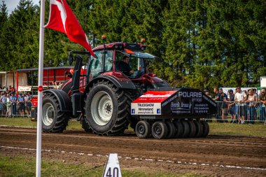 Aarhus, Danimarka. 16 Ağustos 2025 Güçlü makinelerin neşeli festival kalabalığından önce ağır topları çamura sürüklediği bir yarışma..