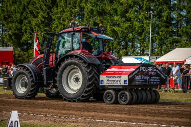 Aarhus, Danimarka. 16 Ağustos 2025 Güçlü makinelerin neşeli festival kalabalığından önce ağır topları çamura sürüklediği bir yarışma..