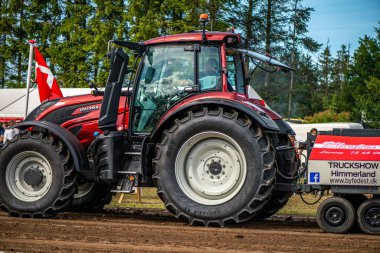 Aarhus, Danimarka. 16 Ağustos 2025 Güçlü makinelerin neşeli festival kalabalığından önce ağır topları çamura sürüklediği bir yarışma..