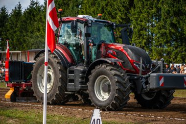 Aarhus, Danimarka. 16 Ağustos 2025 Güçlü makinelerin neşeli festival kalabalığından önce ağır topları çamura sürüklediği bir yarışma..