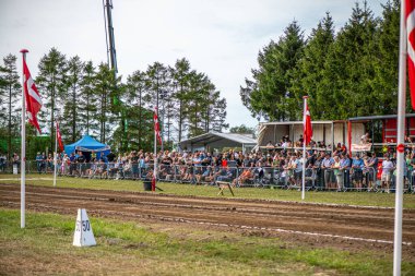 Aarhus, Danimarka. 16 Ağustos 2025 Güçlü makinelerin neşeli festival kalabalığından önce ağır topları çamura sürüklediği bir yarışma..