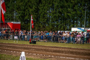 Aarhus, Danimarka. 16 Ağustos 2025 Güçlü makinelerin neşeli festival kalabalığından önce ağır topları çamura sürüklediği bir yarışma..