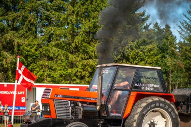 Aarhus, Danimarka. 16 Ağustos 2025 Güçlü makinelerin neşeli festival kalabalığından önce ağır topları çamura sürüklediği bir yarışma..