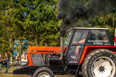 Aarhus, Danimarka. 16 Ağustos 2025 Güçlü makinelerin neşeli festival kalabalığından önce ağır topları çamura sürüklediği bir yarışma..