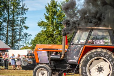 Aarhus, Danimarka. 16 Ağustos 2025 Güçlü makinelerin neşeli festival kalabalığından önce ağır topları çamura sürüklediği bir yarışma..