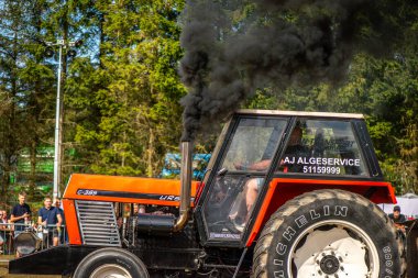 Aarhus, Danimarka. 16 Ağustos 2025 Güçlü makinelerin neşeli festival kalabalığından önce ağır topları çamura sürüklediği bir yarışma..