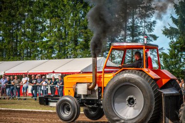 Aarhus, Danimarka. 16 Ağustos 2025 Güçlü makinelerin neşeli festival kalabalığından önce ağır topları çamura sürüklediği bir yarışma..