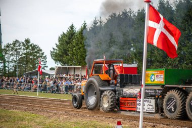 Aarhus, Danimarka. 16 Ağustos 2025 Güçlü makinelerin neşeli festival kalabalığından önce ağır topları çamura sürüklediği bir yarışma..