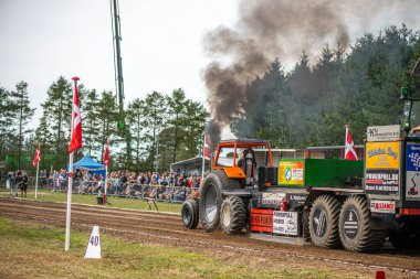 Aarhus, Danimarka. 16 Ağustos 2025 Güçlü makinelerin neşeli festival kalabalığından önce ağır topları çamura sürüklediği bir yarışma..
