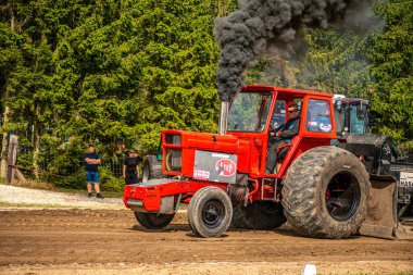Aarhus, Danimarka. 16 Ağustos 2025 Güçlü makinelerin neşeli festival kalabalığından önce ağır topları çamura sürüklediği bir yarışma..