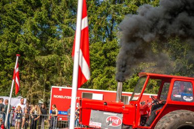 Aarhus, Danimarka. 16 Ağustos 2025 Güçlü makinelerin neşeli festival kalabalığından önce ağır topları çamura sürüklediği bir yarışma..