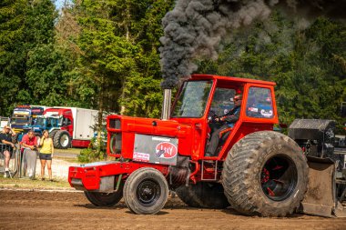 Aarhus, Danimarka. 16 Ağustos 2025 Güçlü makinelerin neşeli festival kalabalığından önce ağır topları çamura sürüklediği bir yarışma..
