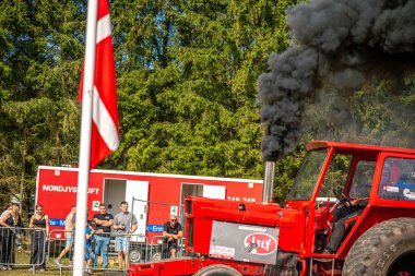 Aarhus, Danimarka. 16 Ağustos 2025 Güçlü makinelerin neşeli festival kalabalığından önce ağır topları çamura sürüklediği bir yarışma..
