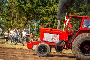 Aarhus, Danimarka. 16 Ağustos 2025 Güçlü makinelerin neşeli festival kalabalığından önce ağır topları çamura sürüklediği bir yarışma..