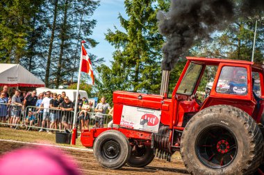 Aarhus, Danimarka. 16 Ağustos 2025 Güçlü makinelerin neşeli festival kalabalığından önce ağır topları çamura sürüklediği bir yarışma..