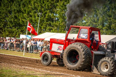 Aarhus, Danimarka. 16 Ağustos 2025 Güçlü makinelerin neşeli festival kalabalığından önce ağır topları çamura sürüklediği bir yarışma..