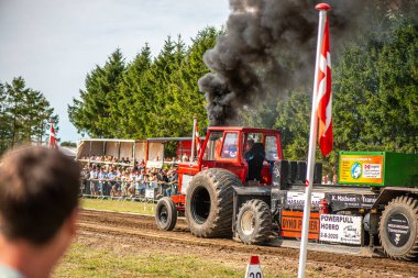 Aarhus, Danimarka. 16 Ağustos 2025 Güçlü makinelerin neşeli festival kalabalığından önce ağır topları çamura sürüklediği bir yarışma..