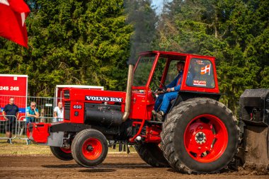 Aarhus, Danimarka. 16 Ağustos 2025 Güçlü makinelerin neşeli festival kalabalığından önce ağır topları çamura sürüklediği bir yarışma..