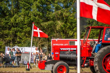 Aarhus, Danimarka. 16 Ağustos 2025 Güçlü makinelerin neşeli festival kalabalığından önce ağır topları çamura sürüklediği bir yarışma..