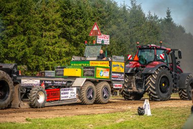 Aarhus, Danimarka. 16 Ağustos 2025 Güçlü makinelerin neşeli festival kalabalığından önce ağır topları çamura sürüklediği bir yarışma..