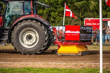 Aarhus, Danimarka. 16 Ağustos 2025 Güçlü makinelerin neşeli festival kalabalığından önce ağır topları çamura sürüklediği bir yarışma..
