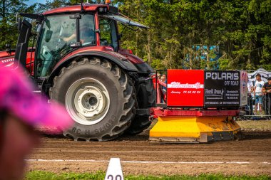 Aarhus, Danimarka. 16 Ağustos 2025 Güçlü makinelerin neşeli festival kalabalığından önce ağır topları çamura sürüklediği bir yarışma..