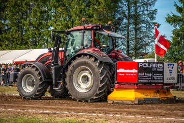 Aarhus, Danimarka. 16 Ağustos 2025 Güçlü makinelerin neşeli festival kalabalığından önce ağır topları çamura sürüklediği bir yarışma..