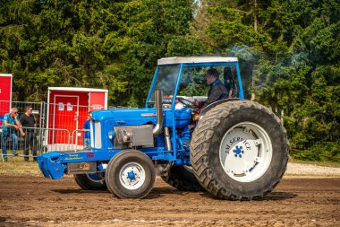 Aarhus, Danimarka. 16 Ağustos 2025 Güçlü makinelerin neşeli festival kalabalığından önce ağır topları çamura sürüklediği bir yarışma..