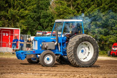 Aarhus, Danimarka. 16 Ağustos 2025 Güçlü makinelerin neşeli festival kalabalığından önce ağır topları çamura sürüklediği bir yarışma..
