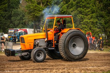 Aarhus, Danimarka. 16 Ağustos 2025 Güçlü makinelerin neşeli festival kalabalığından önce ağır topları çamura sürüklediği bir yarışma..