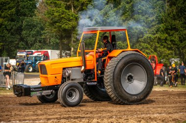 Aarhus, Danimarka. 16 Ağustos 2025 Güçlü makinelerin neşeli festival kalabalığından önce ağır topları çamura sürüklediği bir yarışma..