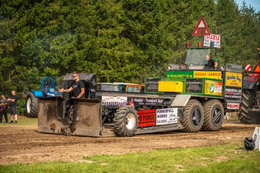 Aarhus, Danimarka. 16 Ağustos 2025 Güçlü makinelerin neşeli festival kalabalığından önce ağır topları çamura sürüklediği bir yarışma..