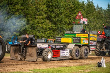 Aarhus, Danimarka. 16 Ağustos 2025 Güçlü makinelerin neşeli festival kalabalığından önce ağır topları çamura sürüklediği bir yarışma..