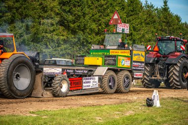 Aarhus, Danimarka. 16 Ağustos 2025 Güçlü makinelerin neşeli festival kalabalığından önce ağır topları çamura sürüklediği bir yarışma..