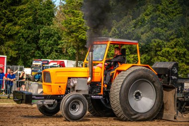 Aarhus, Danimarka. 16 Ağustos 2025 Güçlü makinelerin neşeli festival kalabalığından önce ağır topları çamura sürüklediği bir yarışma..