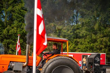 Aarhus, Danimarka. 16 Ağustos 2025 Güçlü makinelerin neşeli festival kalabalığından önce ağır topları çamura sürüklediği bir yarışma..