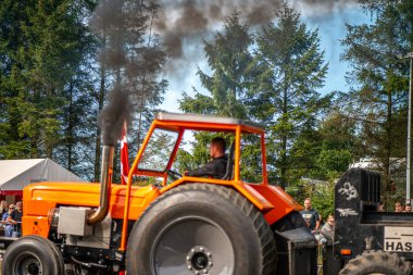 Aarhus, Danimarka. 16 Ağustos 2025 Güçlü makinelerin neşeli festival kalabalığından önce ağır topları çamura sürüklediği bir yarışma..