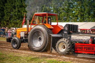 Aarhus, Danimarka. 16 Ağustos 2025 Güçlü makinelerin neşeli festival kalabalığından önce ağır topları çamura sürüklediği bir yarışma..