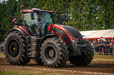 Aarhus, Danimarka. 16 Ağustos 2025 Güçlü makinelerin neşeli festival kalabalığından önce ağır topları çamura sürüklediği bir yarışma..
