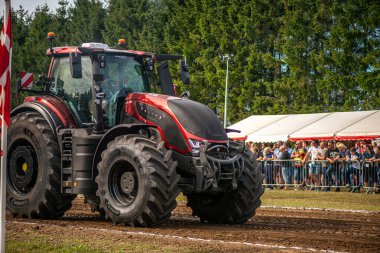 Aarhus, Danimarka. 16 Ağustos 2025 Güçlü makinelerin neşeli festival kalabalığından önce ağır topları çamura sürüklediği bir yarışma..